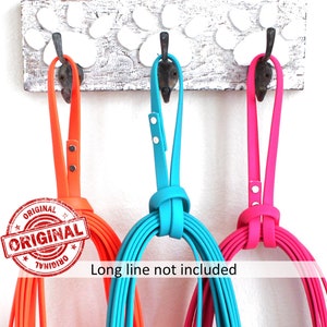 May include: Three colorful dog leashes hanging on a white wooden hook rack with paw print design. The leashes are orange, turquoise, and pink. The text "ORIGINAL" is printed in red on a white circle sticker on the orange leash.