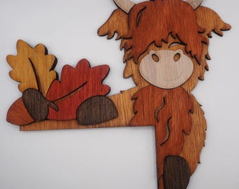 Decorazione per porta a forma di mucca delle Highlands. Graziosa decorazione in legno tinto a mano con motivo a mucca, da posizionare sullo stipite della porta. Decorazione in legno tagliato al laser a strati.