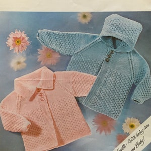 Könnte beinhalten: Zwei gestrickte Baby-Pullover, einer rosa und einer blau, mit Knöpfen. Der blaue Pullover hat eine Kapuze. Das Muster ist ein strukturierter Stich. Das Muster enthält den Text "Lister-Lee BABY LOVE DOUBLE KNITTING" und "K651 Brustumfang 46-51-56 cm. 18-20-22 Zoll."