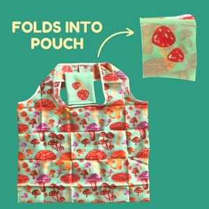 Op de afbeelding: Een herbruikbare boodschappentas met een paddenstoelprint. De tas vouwt in een klein zakje met de tekst "FOLDS INTO POUCH" op de afbeelding.