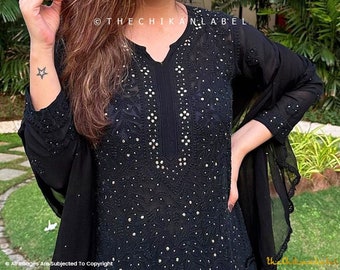 May include: Black embroidered tunic and matching scarf. The tunic features a V-neck and intricate white embellishments. The image includes the text "THE CHIKAN LABEL".