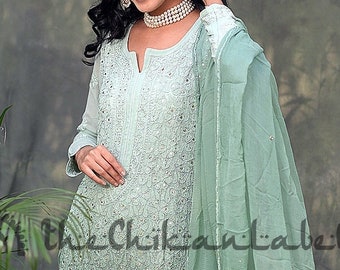 May include: A light green ombre kurta with a matching dupatta and palazzo pants. The kurta is embroidered with silver sequins and beads. The dupatta is sheer and has a scalloped edge. The palazzo pants are wide-legged and flowy.