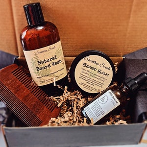 Puede incluir: Un set de regalo para el cuidado de la barba, presentado en una caja. Incluye "Natural Beard Wash", "Beard Balm", "Whiskey Beard Oil" y un peine de madera. Los productos son de "Seventeen Scents".