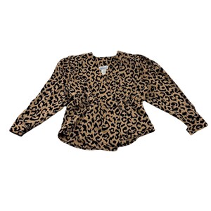 May include: A long-sleeved blouse with a leopard print pattern in black and tan. The blouse has a V-neckline and a cinched waist. The sleeves are long and slightly puffed at the shoulders. The fabric appears to be a lightweight material.