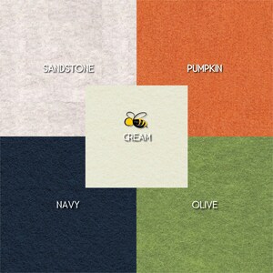 May include: A color palette chart with five different colors: sandstone, pumpkin, cream, navy, and olive. The word "CREAM" is written in black text on the cream square, with a small bee illustration above it.