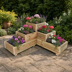 May include: A tiered wooden planter box with a corner design, featuring four distinct rectangular sections arranged in a stepped formation. The natural light-coloured wood structure is filled with various colourful flowers including pink, purple, and white blooms.