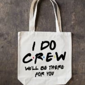 May include: White canvas tote bag with black text that reads "I DO CREW WE'LL BE THERE FOR YOU". The text is stylized to look like the Friends logo.