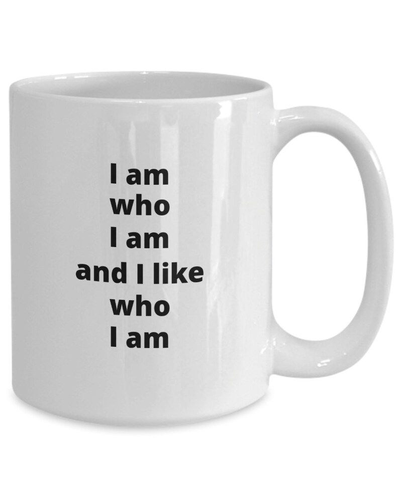 Puede incluir: Taza de cer&aacute;mica blanca con asa curvada. La taza presenta el texto "I am who I am and I like who I am" en negro, alineado verticalmente. La taza est&aacute; dise&ntilde;ada para bebidas calientes.