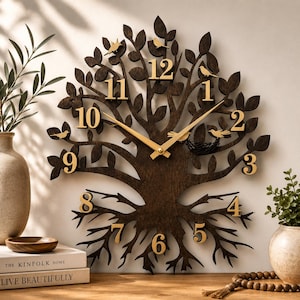 May include: A dark brown wooden wall clock shaped like a tree with exposed roots and branches. The clock features gold-colored numbers from one to twelve, gold-colored clock hands, and small gold-colored bird silhouettes perched on the branches.
