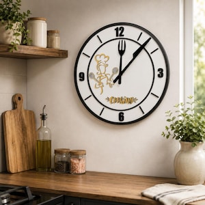 May include: A round wall clock with a white face and black frame. The clock features black numbers at 3, 6, 9, and 12, a black fork as the hour hand, a black knife as the minute hand, and a gold chef silhouette with the word Cooking printed below.