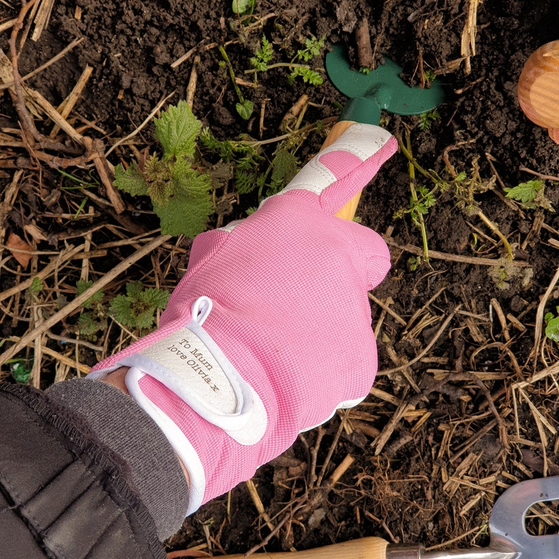 May include: Pink gardening gloves with a white cuff and a personalized message that reads "To Mum Love Olivia x".
