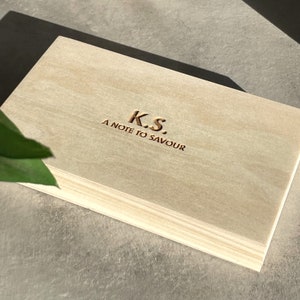 May include: A wooden box with the text "K.S. A NOTE TO SAVOUR" engraved on the top.