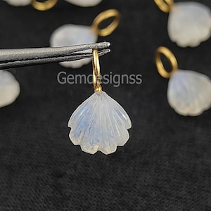 May include: A set of six gold-plated charms featuring a white moonstone carved into a seashell shape. The charms are perfect for adding a touch of elegance to jewellery projects.