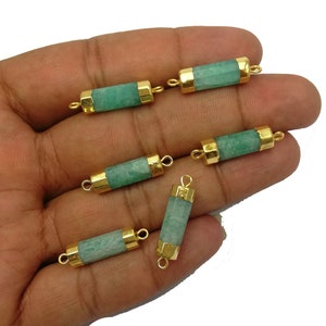 May include: Six green and gold gemstone connector pieces. Each piece is a rectangular tube with gold caps on each end. The caps have a loop on each side for attaching to jewelry.
