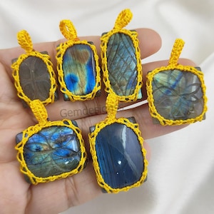 Puede incluir: Seis colgantes de piedra preciosa de labradorita con colores azul y verde iridiscentes, engastados en marcos de crochet amarillo.