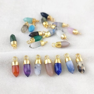 Può includere: Assortimento di ciondoli pendenti in pietra preziosa con montature placcate oro. I ciondoli presentano una varietà di colori e forme, tra cui ametista, corniola, lapislazzuli e quarzo rosa.