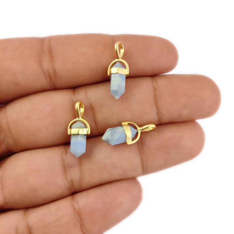 May include: Three gold-plated pendants featuring blue labradorite crystal points. Each pendant has a gold loop at the top for attaching to a chain or cord.
