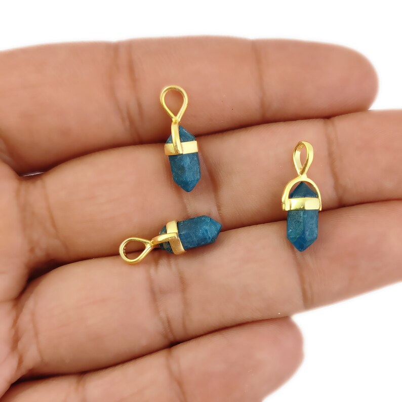 May include: Three gold-plated pendant charms featuring blue gemstone points. Each charm has a gold loop for attaching to a necklace or bracelet.