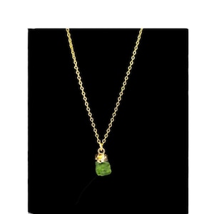 Pode incluir: Um colar de corrente de ouro com um pequeno pingente de pedra preciosa verde bruta.