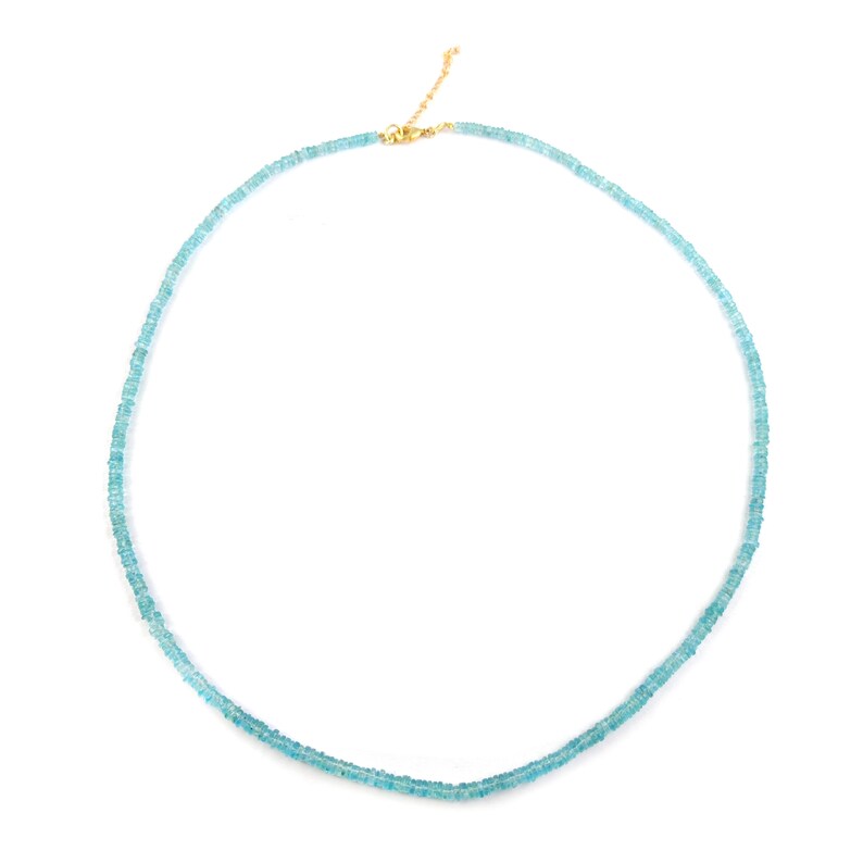 May include: A delicate necklace featuring small, light blue beads. The beads are strung together to form a double strand. The necklace has a gold-colored clasp and chain. The jewelry is displayed against a white background.