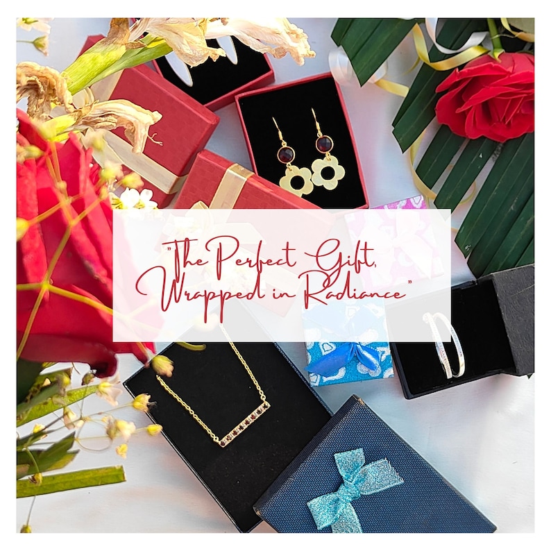 May include: Three gift boxes with jewelry inside. The boxes are wrapped in red, blue, and black paper. The jewelry includes a gold necklace with a bar pendant, a pair of gold earrings with red stones and flower-shaped charms, and a pair of gold bangle bracelets. The text "The Perfect Gift, Wrapped in Radiance" is written on a white background.