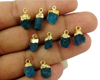 May include: Ten gold-plated blue kyanite gemstone pendants. Each pendant is a raw, natural crystal with a gold-plated bail.