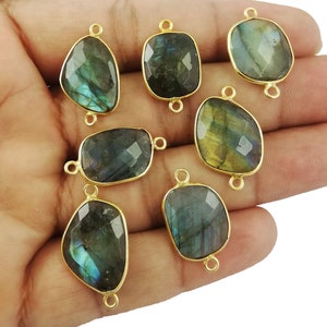May include: Eight gold-toned gemstone connector charms with a teardrop and rectangular shape. The gemstones are iridescent green and blue labradorite.
