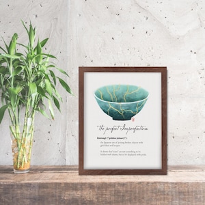 May include: A framed print featuring a teal bowl with gold accents, illustrating the Japanese art of Kintsugi. The text reads "The perfect Imperfection" and explains the philosophy of embracing flaws.
