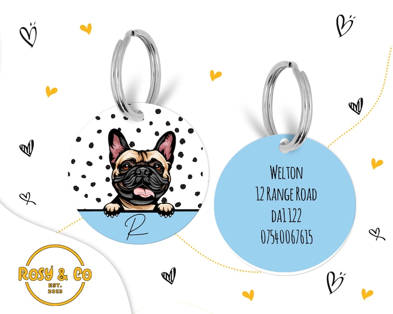 Puede incluir: Dos chapas redondas para perros con fondo azul. Una chapa presenta un bulldog franc&eacute;s de dibujos animados con lunares negros y blancos. La otra chapa tiene el texto "WELTON", "12 RANGE ROAD", "DAL 122" y "07540067615".