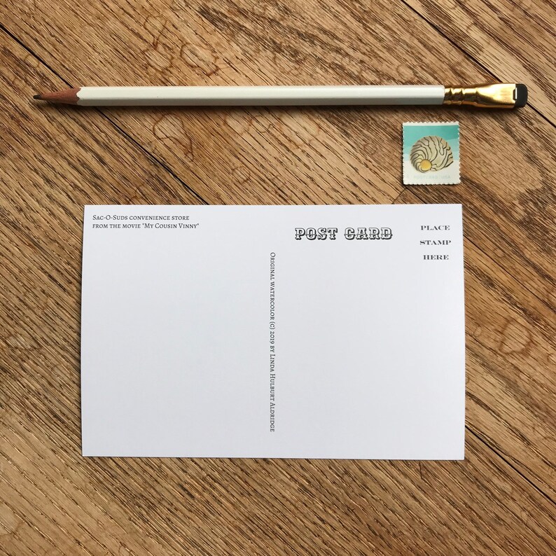 K&ouml;nnte beinhalten: Eine wei&szlig;e Postkarte mit schwarzem Text, der "POST CARD" und "PLACE STAMP HERE" lautet. Der Text "SAC-O-SUDS CONVENIENCE STORE FROM THE MOVIE "MY COUSIN VINNY" ist oben links gedruckt. Der Text "ORIGINAL WATERCOLOR (C) 2009 BY LINDA HULBURT ALDRIDGE" ist unten links gedruckt.