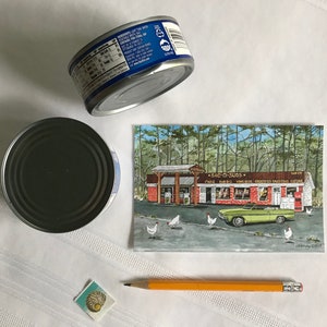 K&ouml;nnte beinhalten: Eine Vintage-Postkarte mit einem gr&uuml;nen Auto, das an einem rot-wei&szlig;en Geb&auml;ude mit dem Text "SAC-O-SUDS" und einem Schild mit der Aufschrift "PIZZA BAR-B-Q WINES GROCERIES & GREETING CARDS" vorbeif&auml;hrt, mit einem Wald im Hintergrund und wei&szlig;en H&uuml;hnern im Vordergrund.