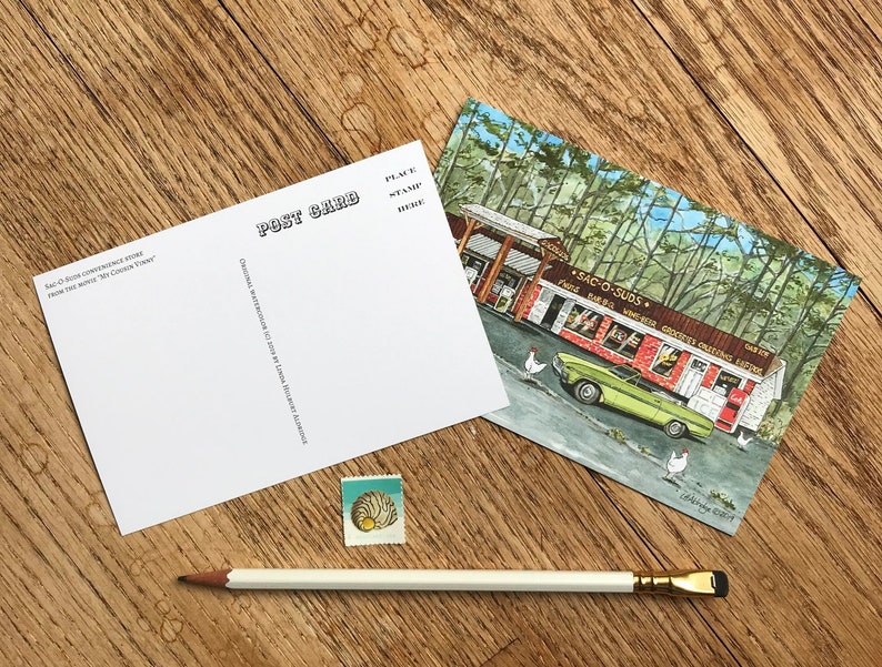 K&ouml;nnte beinhalten: Eine Vintage-Postkarte mit einer Aquarell-Illustration eines gr&uuml;nen Autos, das vor einem roten Backsteingeb&auml;ude mit dem Text "Sac-O-Suds" und "Food, Baked Goods, Groceries, Greeting Cards, Gifts" auf der Seite geparkt ist. Das Geb&auml;ude ist von B&auml;umen umgeben und im Vordergrund befinden sich H&uuml;hner.