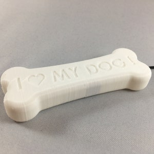 May include: White bone-shaped keychain with the text "I ♥ MY DOG!" engraved on it.