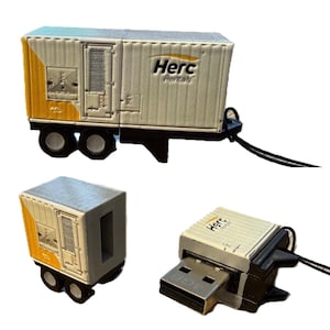 Könnte beinhalten: Ein weiß-gelber USB-Stick in Form eines Herc Rentals-Anhängers. Das Gerät verfügt über eine geriffelte Außenseite, schwarze Räder und ein schwarzes Schlüsselband. Eine Ansicht zeigt den Anhänger, eine andere den USB-Anschluss.
