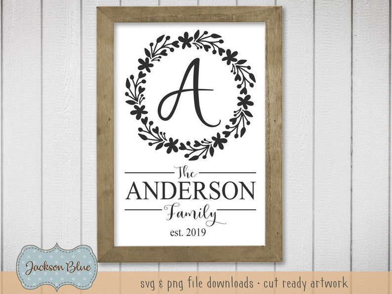 Op de afbeelding: Een zwart-wit bord met een bloemenkrans rond de letter "A". De tekst "The Anderson Family est. 2019" staat onder de krans.
