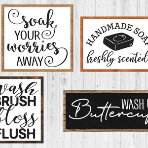 May include: Four wooden framed signs with black calligraphy and text. The signs read "soak your worries away", "handmade soap freshly scented", "wash brush floss flush", and "Buttercup wash up".