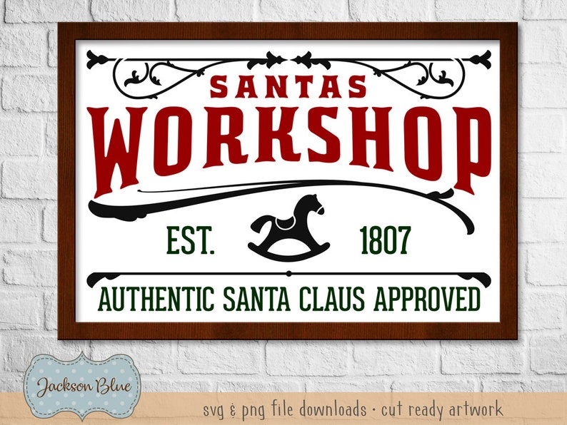 May include: A brown wooden framed sign with white background and black lettering. The sign reads "Santas Workshop Est. 1807 Authentic Santa Claus Approved".