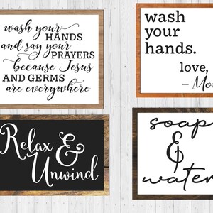 May include: Four wooden signs with white backgrounds and black lettering. The signs feature bathroom-themed messages: "Wash your hands and say your prayers because Jesus and germs are everywhere", "Wash your hands. Love, Mom", "Relax & Unwind", and "Soap & Water".