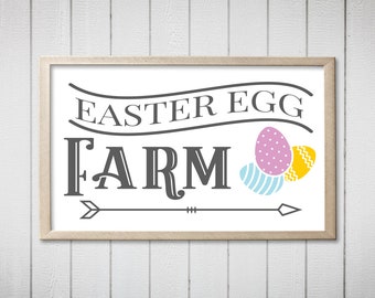 May include: A white sign with a brown frame that says "Easter Egg Farm" in black text. There are three stylized eggs in the upper right corner of the sign: one pink with white dots, one yellow with a zig-zag pattern, and one blue with white stripes.