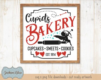 Op de afbeelding: Een wit bord met een bruin houten frame, met de tekst "Cupid's Bakery" in rode en zwarte letters. Het bord bevat ook een silhouet van Cupido met een pijl, een deegroller en de tekst "Cupcakes Sweets Cookies Est. 1814".