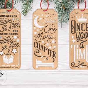 May include: Three wooden bookmarks with different quotes. The first bookmark says "Some books leave us free and some books make us free." The second bookmark says "Just one more chapter." The third bookmark says "Once upon a time."