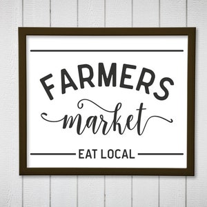 May include: A black and white sign with a brown frame that reads "Farmers market - Eat Local".