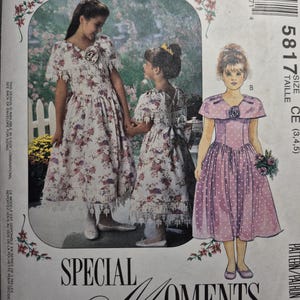May include: McCall's sewing pattern for a girl's dress, size CE (3, 4, 5). The pattern features two girls wearing dresses with floral and polka dot prints. The text "Special Moments" is printed on the bottom of the pattern.