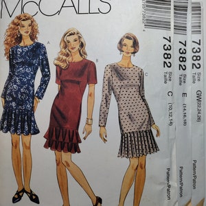 May include: McCall's sewing pattern envelope for a dress with three different styles. The pattern number is 7382 and the sizes are GW(22,24,26), E(14,16,18), and C(10,12,14).