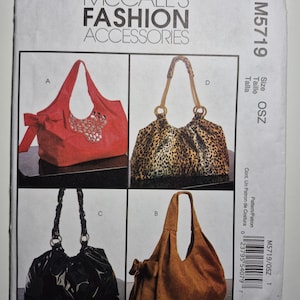 May include: A pattern for McCall's Fashion Accessories, featuring four different handbag designs. The bags include a red tote with a bow and embellishments, a leopard print bag, a black patent leather bag, and a brown suede bag with a bow.