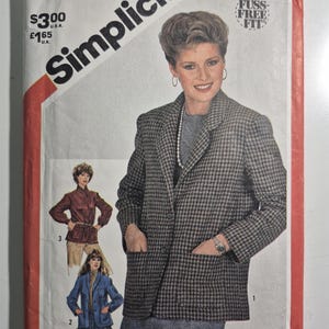 May include: Simplicity sewing pattern, size 12, featuring a woman in a houndstooth blazer. The pattern includes instructions for making a blazer and other garments. The cover has the text "Fuss-Free Fit".