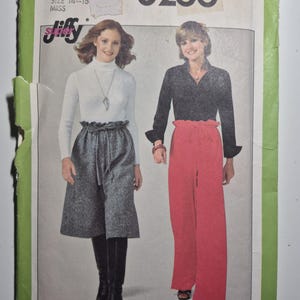 May include: Vintage Simplicity sewing pattern 8266 featuring two women modeling different outfits. The pattern includes a skirt, pants, and tops. The pattern is for a medium size 14-16. The cover is green and white.