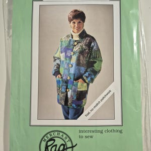 May include: A sewing pattern envelope titled Noelle's Jacket by Merchant & Mills, featuring a photograph of a long-sleeved, button-front jacket made from a multi-colored patchwork fabric in shades of blue, green, and purple, with a high collar.