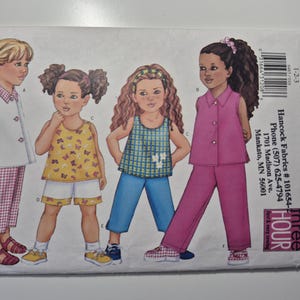 May include: Butterick sewing pattern envelope featuring illustrations of children's clothing. The pattern includes designs for tops, shorts, and pants. The envelope is white with text and the number 6485. The words "FAST & EASY" are also visible.