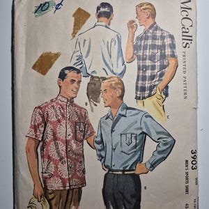 May include: Vintage McCall's printed pattern for men's sports shirts. The cover features illustrations of men wearing different shirt styles, including a plaid short-sleeve shirt and a floral print shirt. The pattern number is 3903.